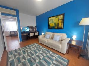 a living room with a white couch and a blue wall at Holiday Art Garden&Spa in Balatonfüred