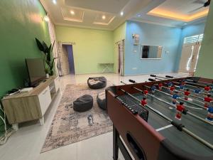 a living room with a pool table and a tv at Villa Dr Din in Rantau Panjang +21 photos