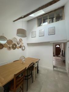 a dining room with a wooden table and chairs at LAtypique in Beaumont-sur-Sarthe