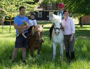 a family posing for a picture with two horses and a woman at Clara Elisabeth in Döhnsdorf