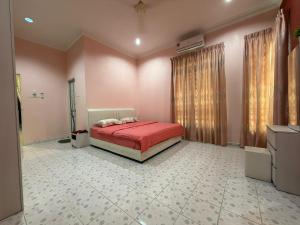 a bedroom with a red bed in a room at Villa Dr Din in Rantau Panjang