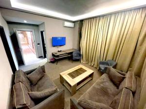 a living room with a couch and a table and a tv at Rawsheh Boutique Hotel in Beirut