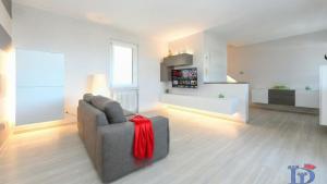 a living room with a gray couch with a red blanket at H2o Green Residence with 3 pools DesenzanoLoft Official Partner Homes & Villas by Marriott Bonvoy in Desenzano del Garda