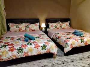 two beds sitting next to each other in a bedroom at 4F Motel and Homestay by LTS in Pantai Cenang