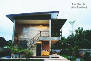 a house with a staircase on the side of it at Ban Roojai in Nan