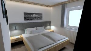 a bedroom with a large white bed and a window at Gästehaus Oberauer in Annaberg im Lammertal