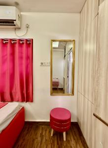 a room with a mirror and a red stool at Cutesy space in Kolkata