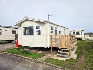 a white tiny house sitting in a parking lot at Beachside Holiday Park in Brean