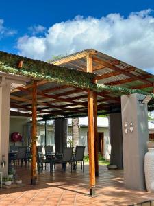 a wooden pergola with chairs and tables on a patio at Guesthouse 52 in Groblersdal