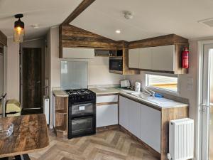 a kitchen with white cabinets and a stove top oven at Beachside Holiday Park in Brean