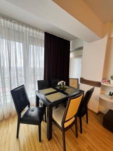 a dining room with a black table and chairs at Class Belvedere Apartments in Oradea