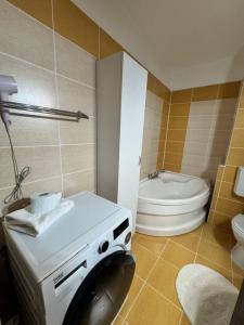 a bathroom with a washing machine and a toilet at Class Belvedere Apartments in Oradea