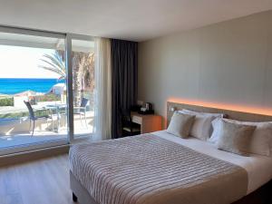 a hotel room with a bed and a view of the ocean at Hôtel La Plage in Sainte-Maxime