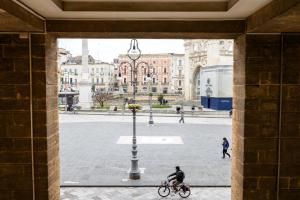 a man riding a bike in a courtyard at B&B Il Sedile in Lecce