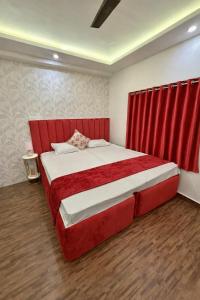 a bedroom with a red bed with red curtains at Cutesy space in Kolkata