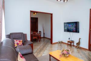 a living room with a couch and a table at Arusha Oasis Executive Residence in Arusha