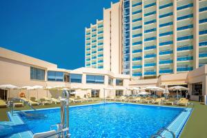 a swimming pool in front of a large building at Hotel Servigroup Koral Beach 4 Sup in Oropesa del Mar