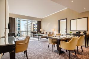a living room with a table and chairs at Golden Tulip Doha Hotel in Doha