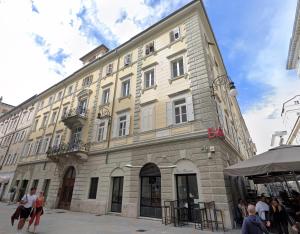 a large building with people standing outside of it at Dimora Vianello Rooms in Trieste