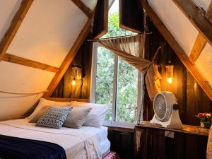 a bedroom with a bed with a window and a fan at Canada House Queen bed in 2nd floor dbl sofa bed in 1st floor BBQ Private pool, river in Jarabacoa +79 photos