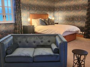 a bedroom with a bed and a blue couch at Recently refurbished former art studio in Rothiemay Station