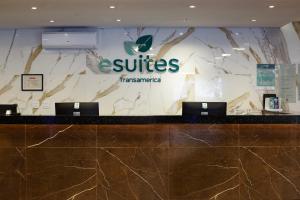 a hotel lobby with a reception desk with two laptops at Esuites Sorocaba in Sorocaba