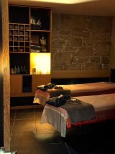two beds in a room with a stone wall at Smartr Porto Reis de Gaia & Spa in Vila Nova de Gaia