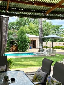 a patio with a table and chairs and a pool at Guesthouse 52 in Groblersdal