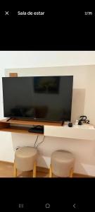 a living room with a table and two stools at Apartamento Próximo Arena pantanal in Cuiabá +6 photos
