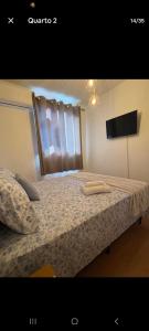 a bedroom with a bed with a window and a tv at Apartamento Próximo Arena pantanal in Cuiabá