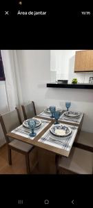 a table with plates and bowls on top of it at Apartamento Próximo Arena pantanal in Cuiabá
