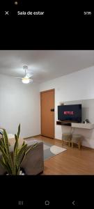 a living room with a couch and a tv on a wall at Apartamento Próximo Arena pantanal in Cuiabá