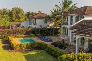 a house with a swimming pool in the yard at Kena Beach Villas in Marumbi