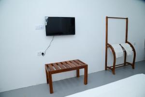 a room with a bench and a tv and a mirror at Amila Resort - Habarana in Habarana