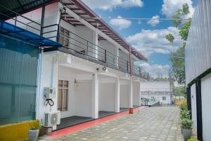 a white building with a balcony on the side at Amila Resort - Habarana in Habarana