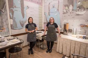 two women are standing in a room with tables at Nuovo Albergo Centro in Trieste