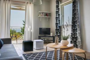 a living room with a blue couch and a table at La SkalaVista in Skala