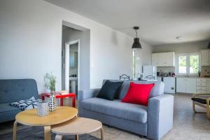 a living room with a blue couch and a red pillow at La SkalaVista in Skala