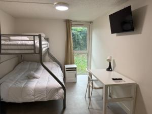 a bedroom with a bunk bed and a desk with a desk at Mot Hotel in Claye-Souilly