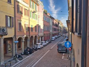 a city street with cars parked on the street at Homeby, Cinisca Suite Rose in Bologna