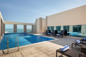 a swimming pool on the roof of a building at Golden Tulip Doha Hotel in Doha