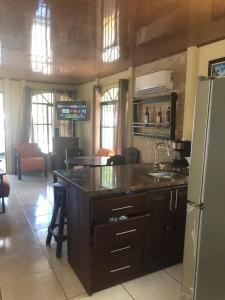 a kitchen with a counter top and a refrigerator at Macaws Villa in Ciudad Cortés