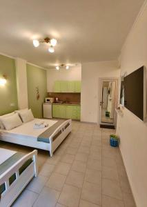 a bedroom with a large bed and a kitchen at Orea Boutique Studios in Asprovalta