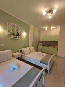 two beds in a room with a kitchen at Orea Boutique Studios in Asprovalta