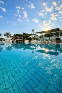 a large swimming pool with blue water at Hotel Liberty Beach - Parking & Beach in Riccione