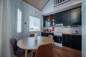 a kitchen with a wooden table with chairs and a candle on it at Villa Luoto A Stylish semi-detached house Incl AC, Sauna, Terrace in Kalajoki