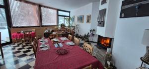 a dining room with a table and a fireplace at La Rotonde des Grânes in La Bâtie-Neuve