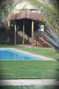 a swimming pool with a pavilion and a picnic table at Pousada Maresia in Guajiru +44 photos