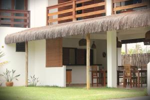 a small house with chairs and a thatched roof at Pousada Maresia in Guajiru