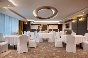 a banquet room with white tables and white chairs at Golden Tulip Doha Hotel in Doha +67 photos
